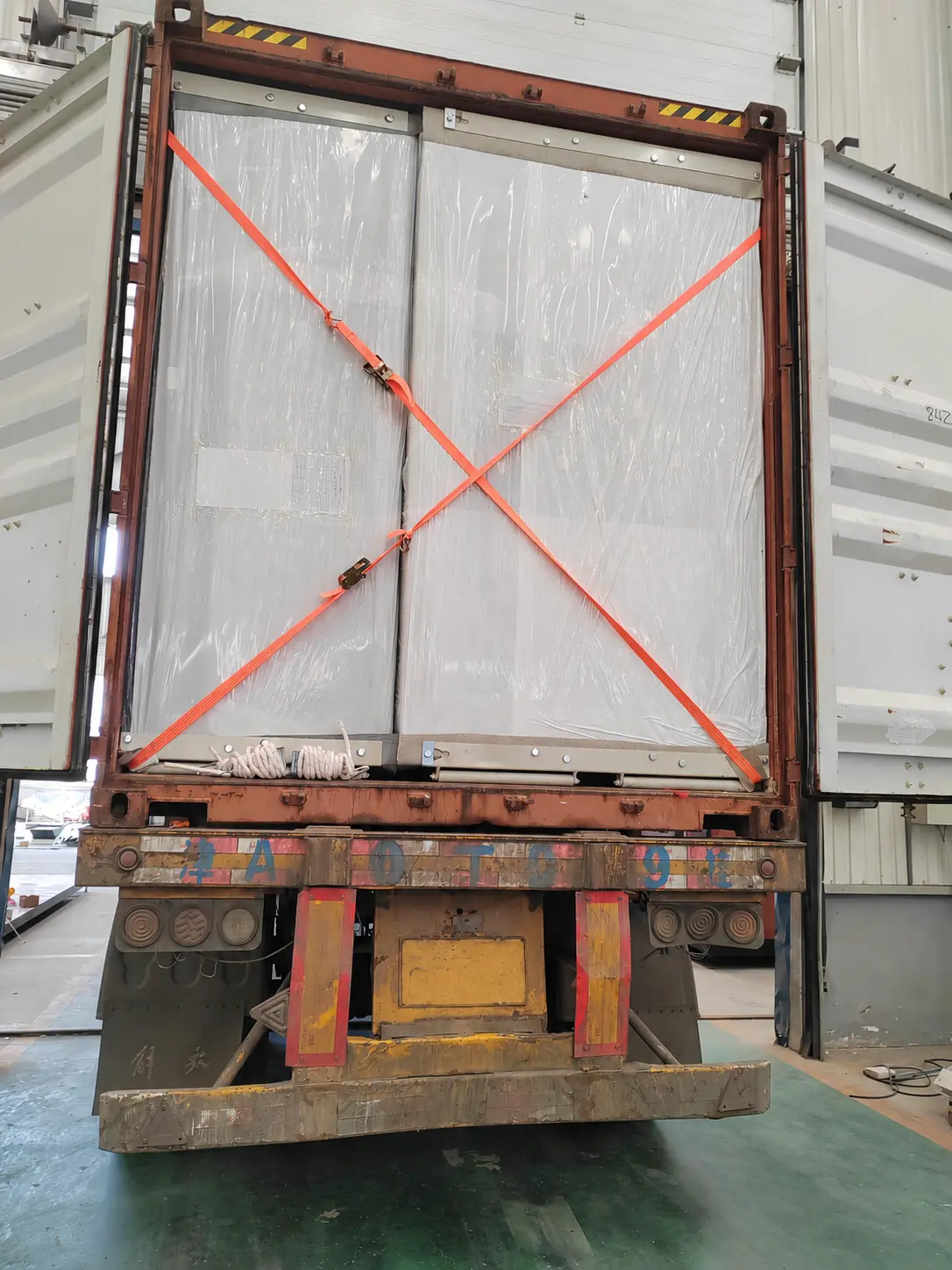 Packed modular building components being loaded for container shipment
