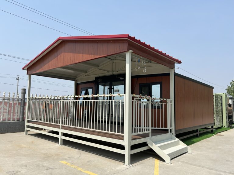 Modular prefab house with a red pitched roof and a covered porch with white railings — MZ ECO