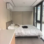 A30 apple cabin bedroom with a double bed beside full-height glazing