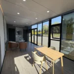 Park apple cabin lounge with a table, chairs and seating beside the glass wall
