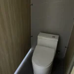 Seated toilet inside a compartment of the public restroom apple cabin
