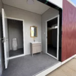 Recessed wash area of the red restroom apple cabin with a vanity and mirror