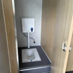 Toilet cubicle in the red restroom apple cabin with a squat toilet