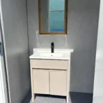 Separate wash area in the shower facilities apple cabin with a vanity and mirror