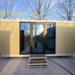 Yellow apple cabin displayed outdoors with steps at the entrance