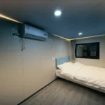 Bedroom inside the yellow apple cabin with a double bed and ceiling light strips