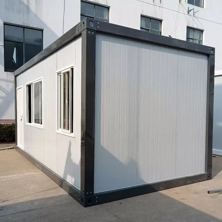 Detachable container house with a dark frame, white panels and a door and windows along the side