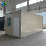 Cream-panel detachable container house with a light frame and an end-wall entrance inside the factory