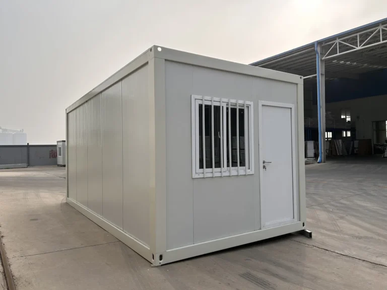 White detachable container house with an end-wall door, barred window and plain side wall