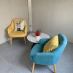 Two chairs and a small round table in the wood-look detachable cabin