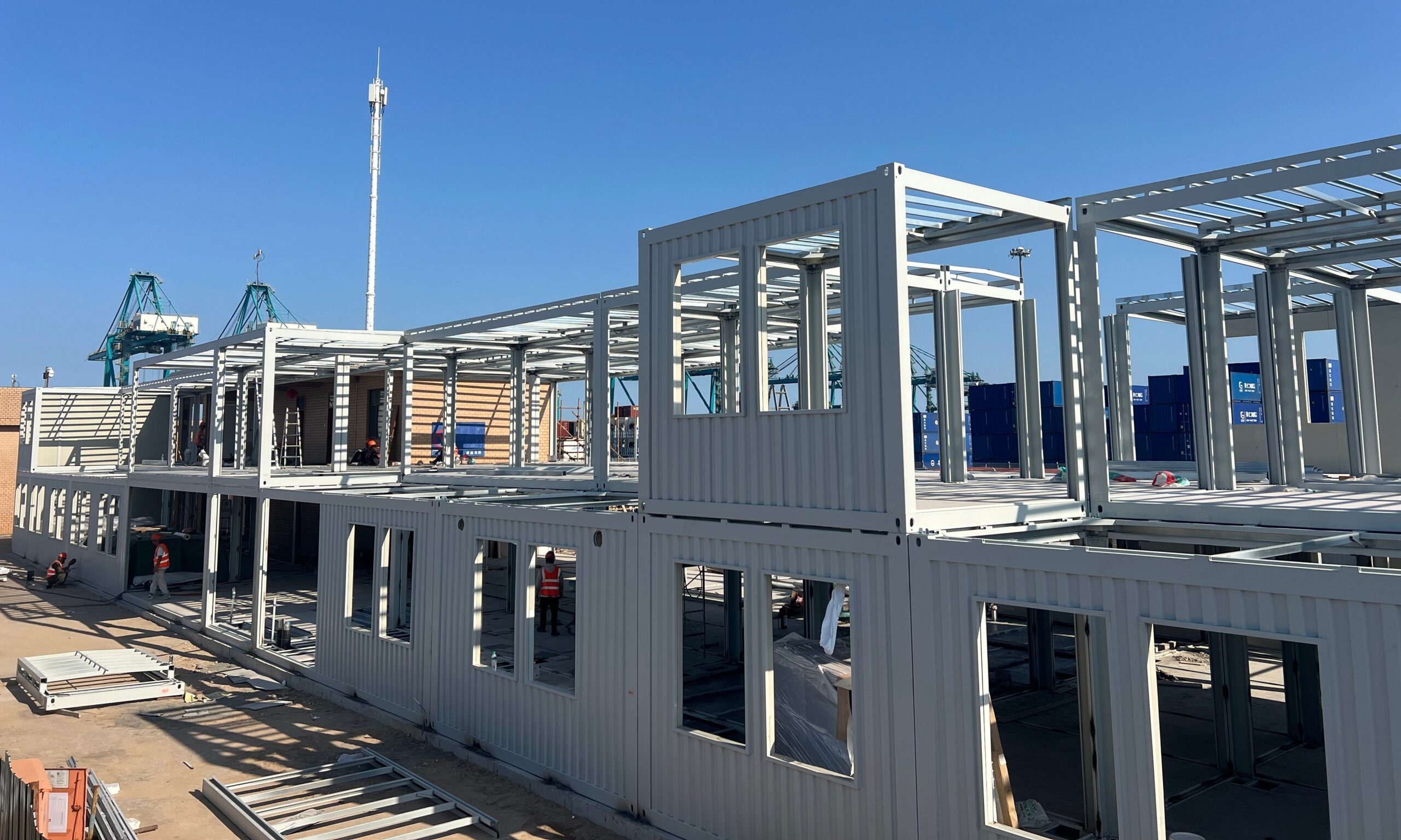 Two-storey MZ ECO container house under construction with steel frames erected and wall panels being installed