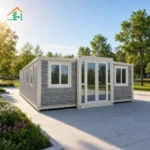Grey stone-look expandable container house reference with white framing and a glazed central entrance