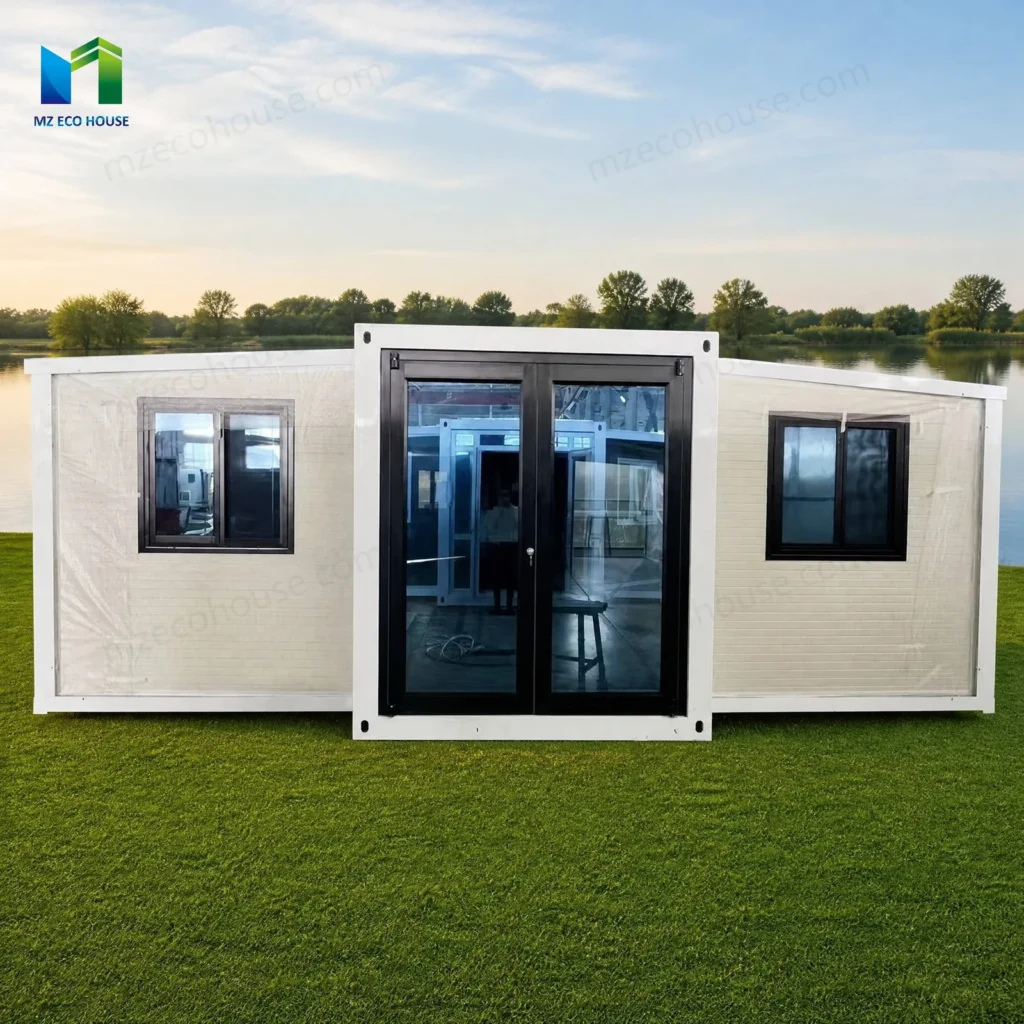 Front reference of a white expandable container house with a dark glazed entrance and windows on both wings