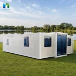 White expandable container house exterior reference showing the glazed entrance and long side wall
