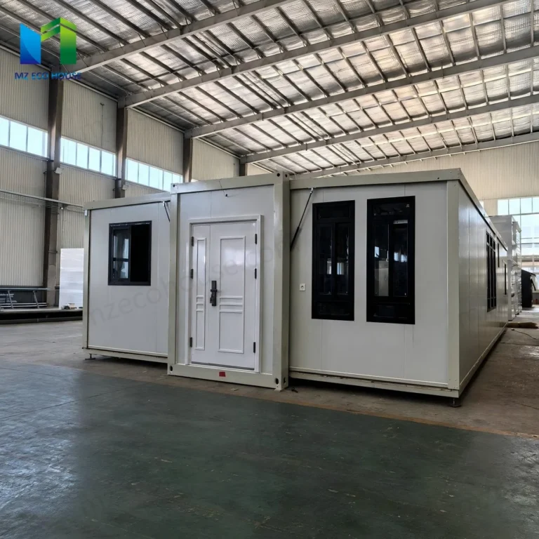 White expandable container house with a central solid entrance door and dark-framed windows in the factory