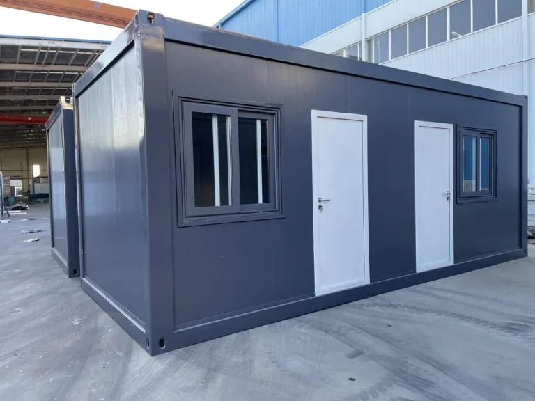 Grey flat pack container cabin with two entrance doors and barred windows