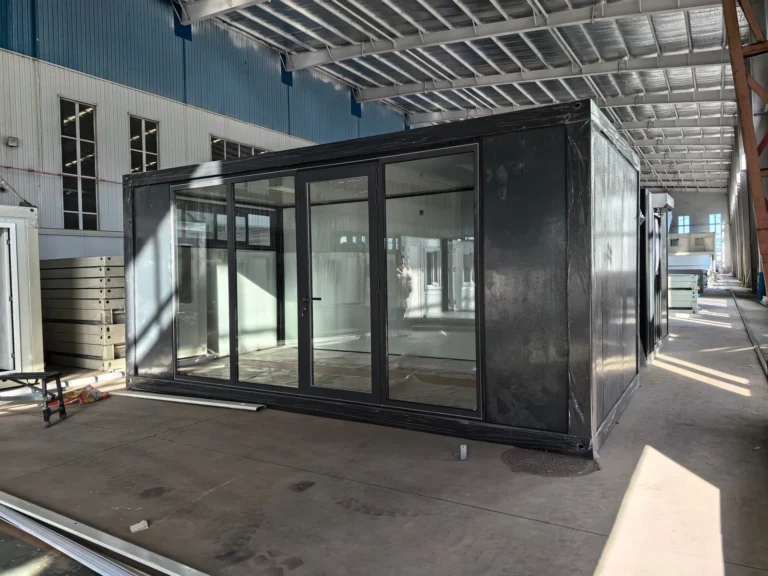 Dark-framed flat pack container office with full-height glazing