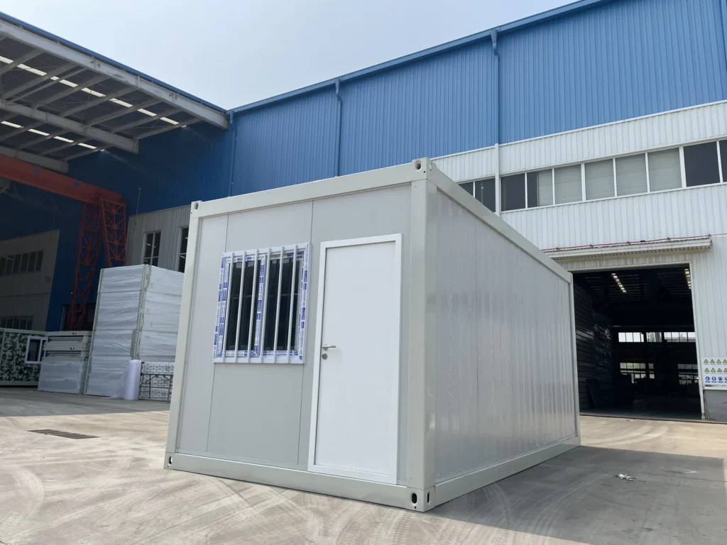 Standard flat pack container house with light-coloured panels and an entrance door