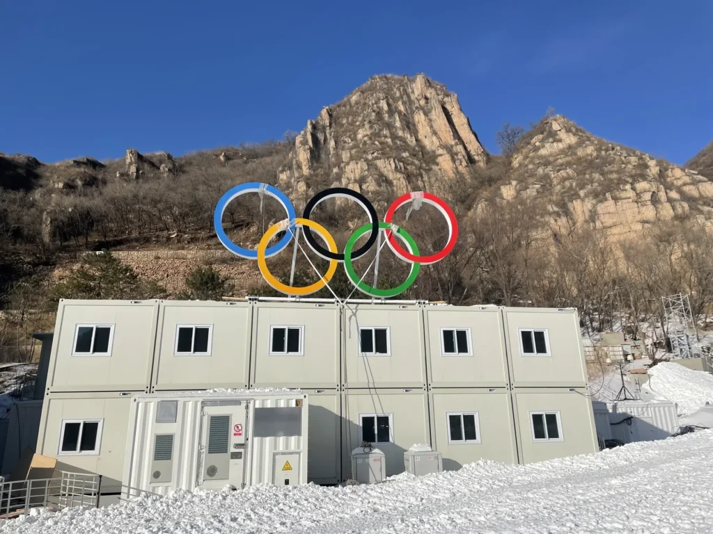 Snow-covered Yanqing modular camp and Olympic rings