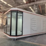 Long assembled space capsule reference with light panels, warm edge trim and a dark glazed end
