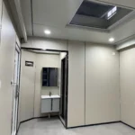 Unfurnished compact capsule interior with a skylight and a doorway to the vanity area
