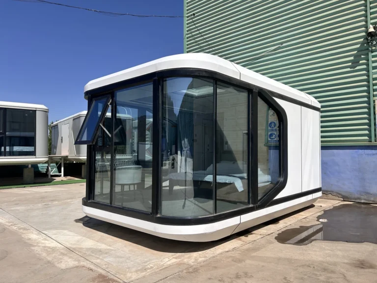 White E30 space capsule house with dark panoramic corner glazing in the outdoor display area
