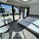 Furnished E30 bedroom with a bed, panoramic windows and a seating area