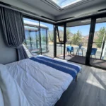 E50 furnished bedroom with panoramic glazing beside the covered balcony