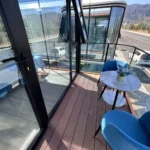 Table and chairs on the E50 covered balcony behind a dark railing