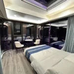 G50S bedroom with a bed, seating area, panoramic glazing and a skylight