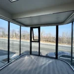 Unfurnished G60S interior with wood-look flooring and broad dark-framed end windows