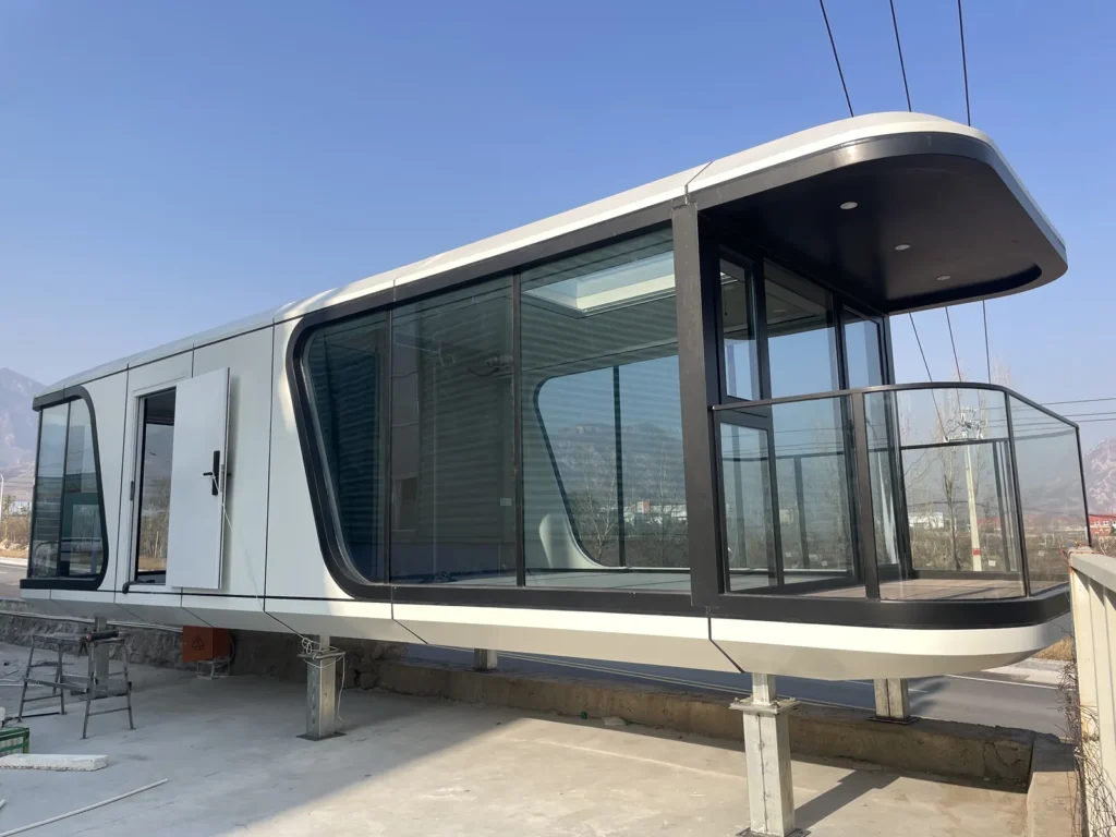G70 space capsule house with an elongated white enclosure, dark glazing and a covered balcony