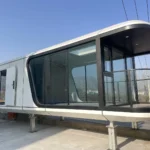 G70 space capsule house with an elongated white enclosure, dark glazing and a covered balcony