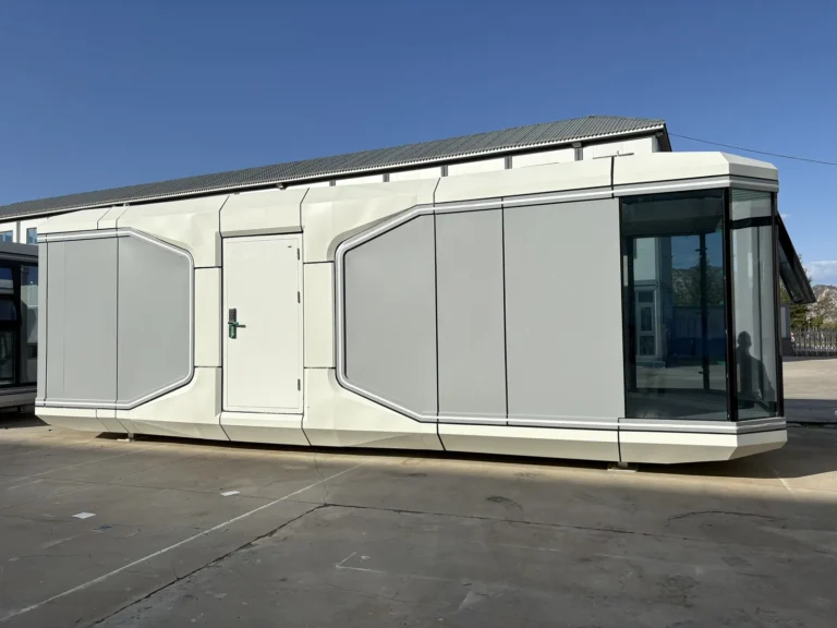 Long white and grey two-room capsule reference with a central side entrance and dark panoramic glazing
