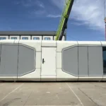 Long side of the 9.5 m capsule reference showing grey geometric panels and a central door