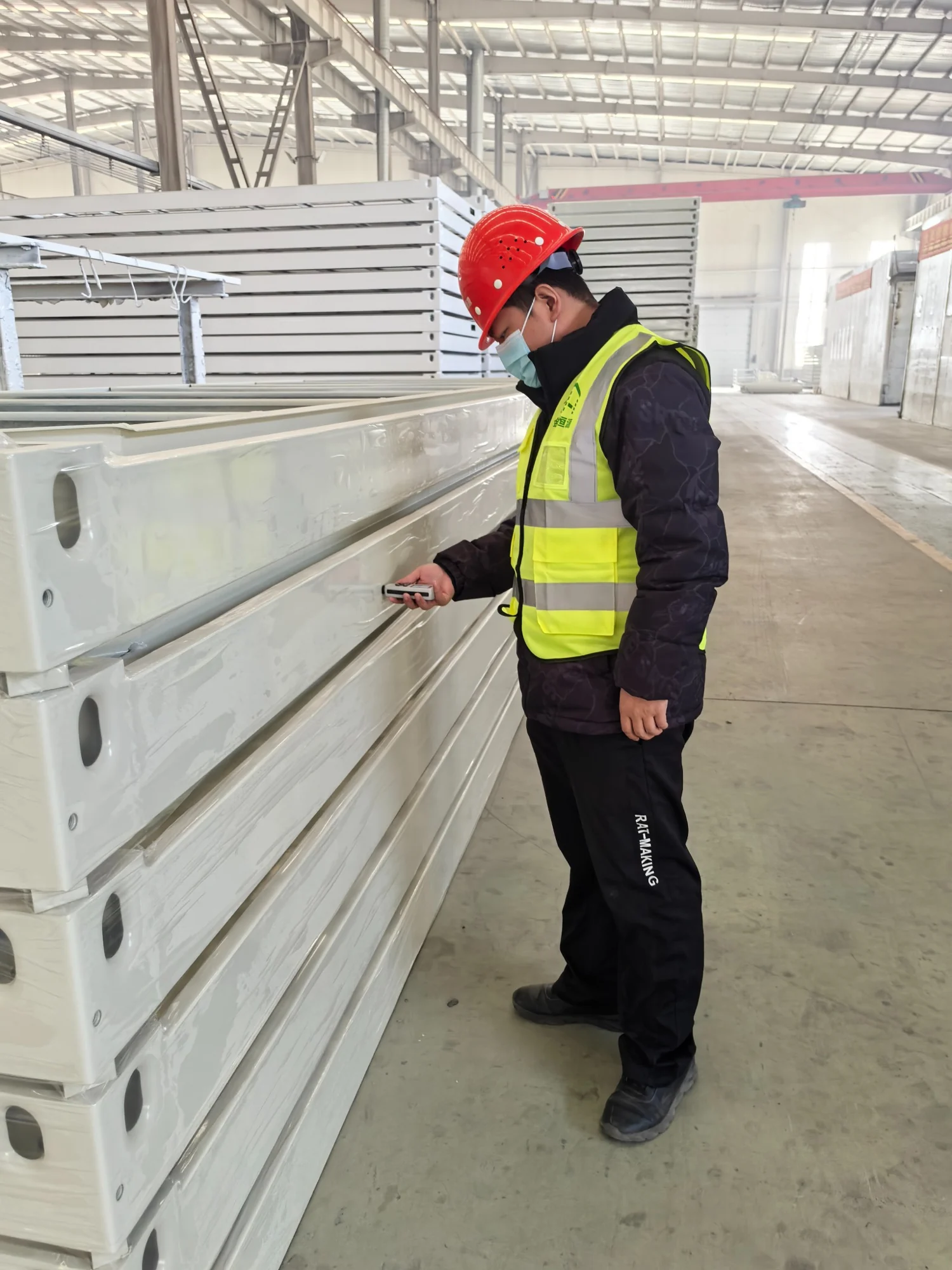 A worker inspecting a modular building panel in the factory