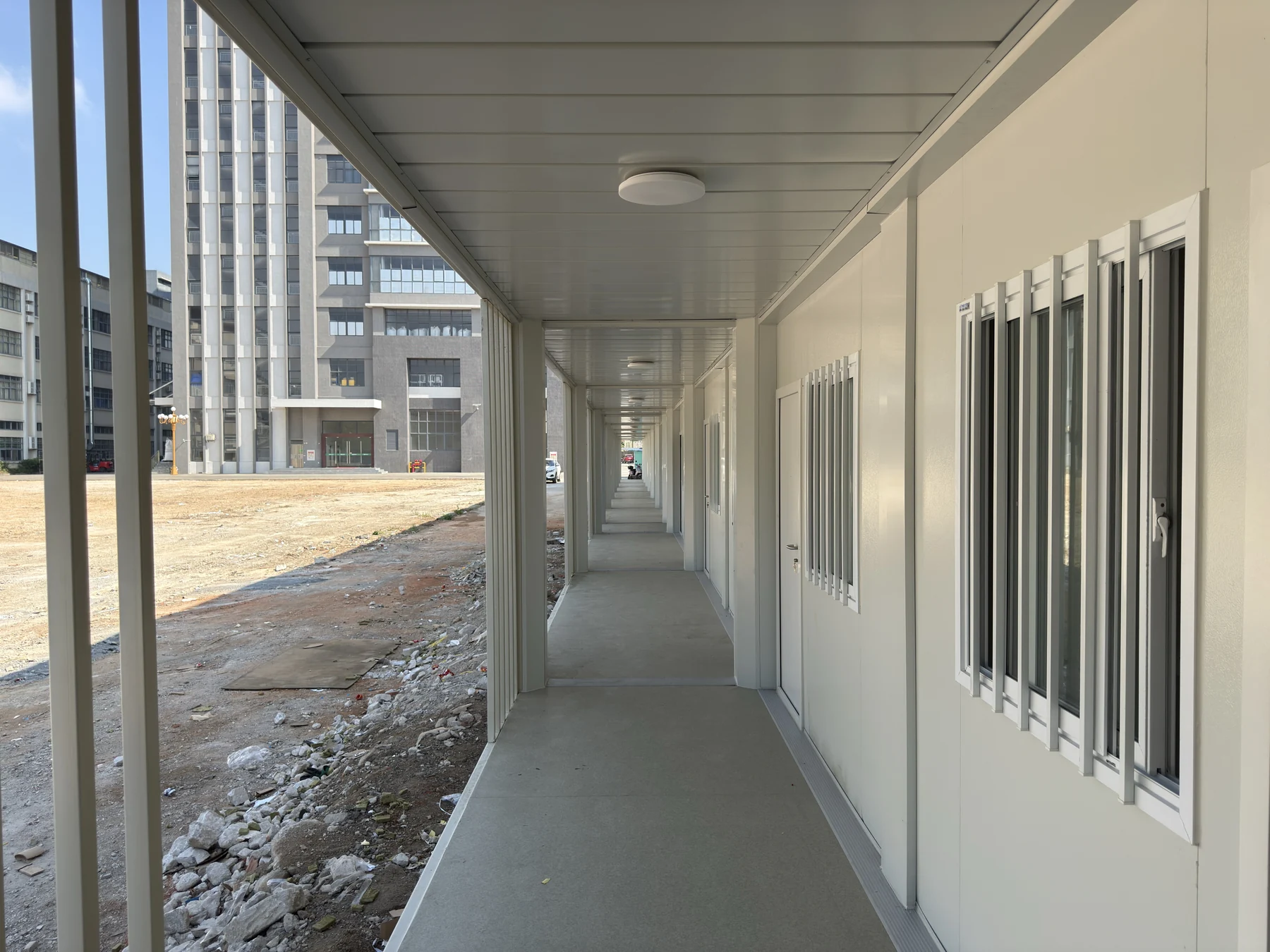 Covered modular building corridor with doors and windows