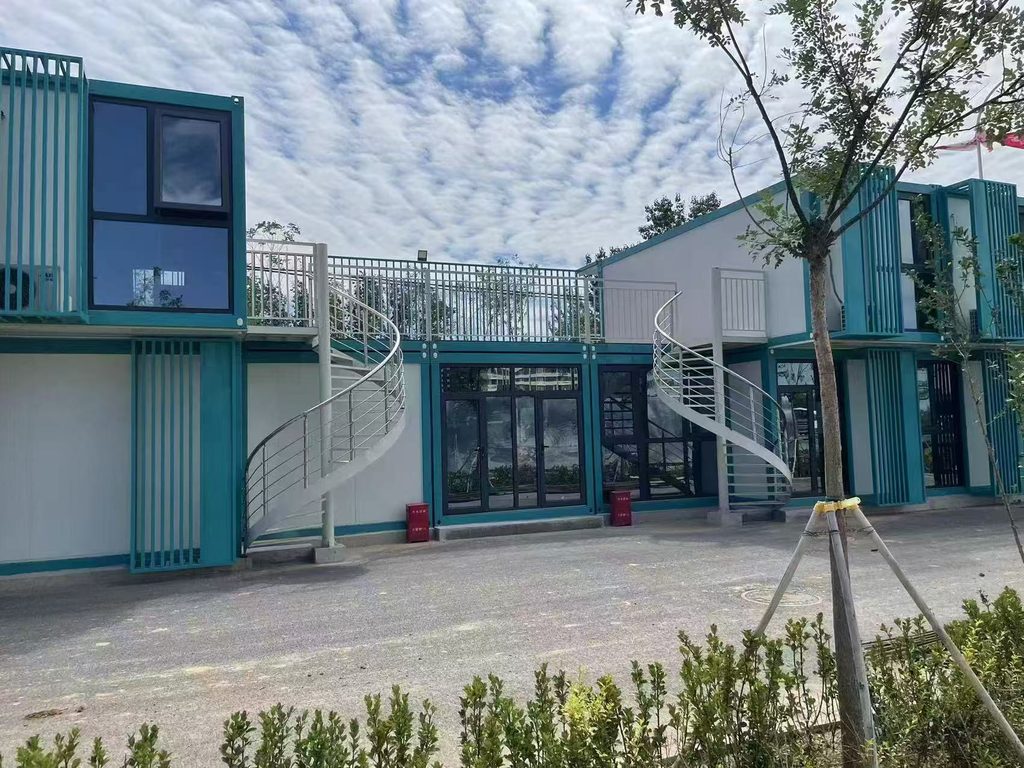Two-storey prefab container office and modular showroom with teal steel facade and glass storefront, MZ ECO HOUSE