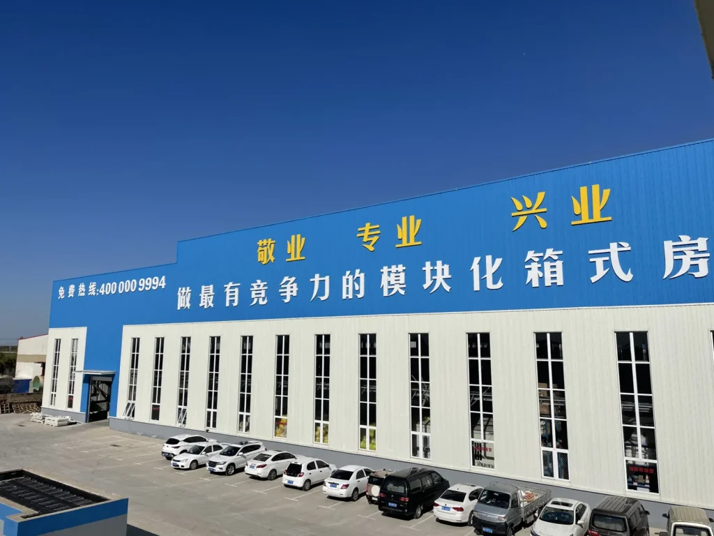 Front view of the MZ ECO container house factory with tall windows along the production hall